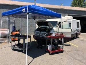 Working on an RV engine under an outdoor canopy